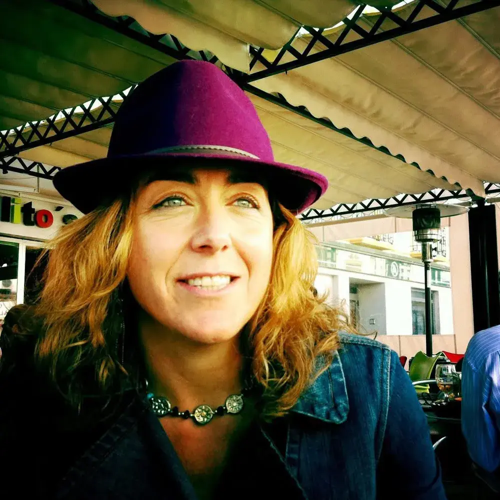 María Ramírez con sombrero fucsia en una terraza