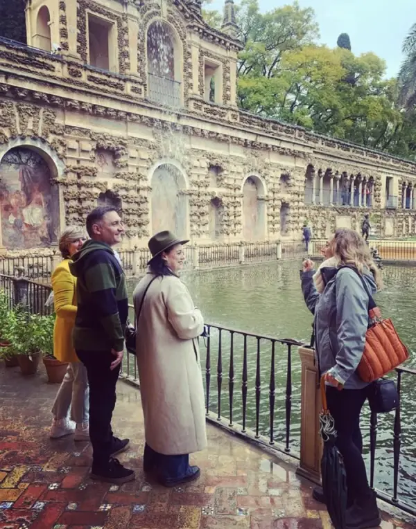 María con un grupo de viajeros junto al estanque de Mercurio en los jardines del Real Alcázar
